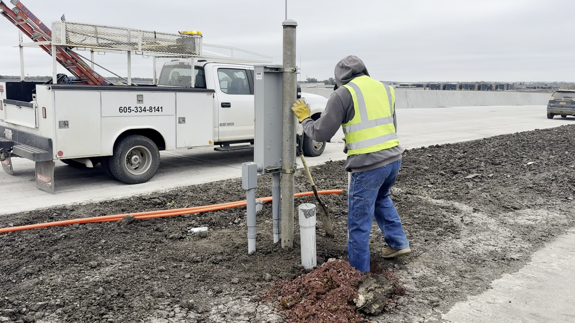 Electrical crews work on street lighting infrastructure along the corridor.